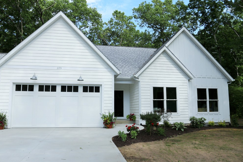 Foto della facciata di una casa bianca country a un piano di medie dimensioni con rivestimento in legno e tetto a padiglione