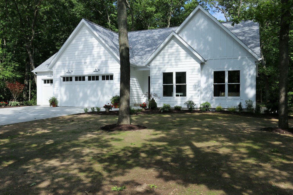 Esempio della facciata di una casa bianca country a un piano di medie dimensioni con rivestimento in legno e tetto a padiglione