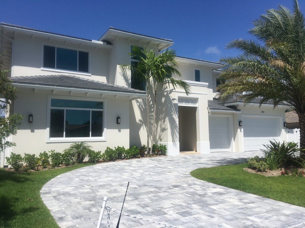 Mid-sized beach style white two-story stucco house exterior photo in Miami with a hip roof and a tile roof