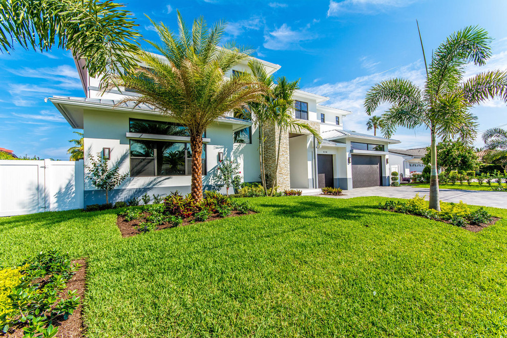 Mittelgroßes, Zweistöckiges Modernes Haus mit Putzfassade und weißer Fassadenfarbe in Miami