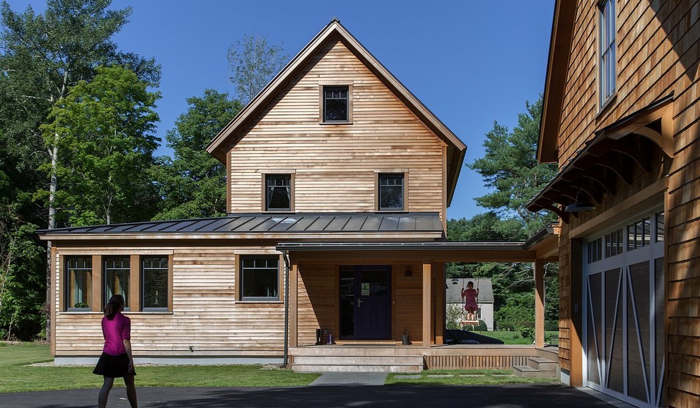 Aménagement d'une façade de maison marron campagne en bois de taille moyenne et à un étage avec un toit à deux pans et un toit en métal.