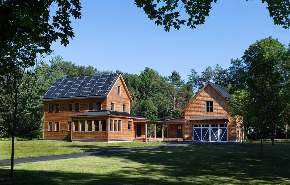 Esempio della villa marrone country a due piani di medie dimensioni con rivestimento in legno, tetto a capanna e copertura in metallo o lamiera