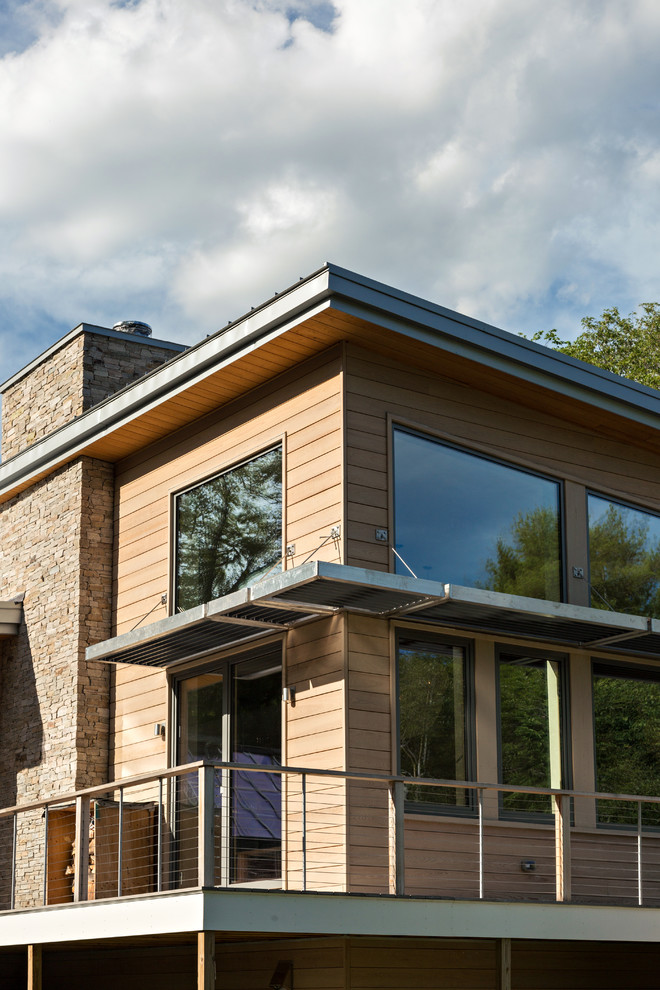 Imagen de fachada de casa beige moderna de tamaño medio de dos plantas con revestimiento de madera, tejado de un solo tendido y tejado de metal