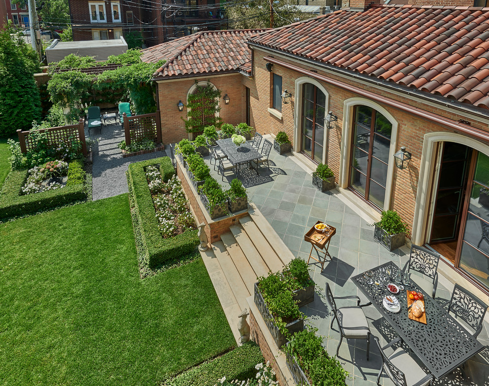 Photo of an expansive mediterranean two floor house exterior in Chicago with a hip roof.