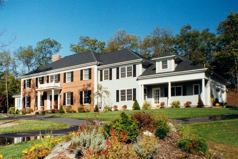 Large elegant two-story brick house exterior photo in Boston with a hip roof and a shingle roof