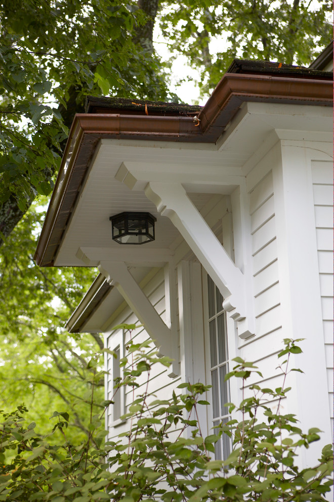 Modelo de fachada de casa blanca de estilo de casa de campo de tamaño medio de dos plantas con revestimiento de madera