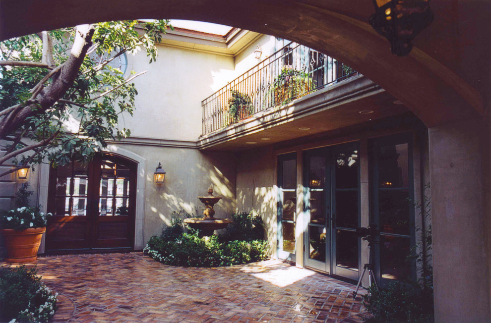 Modelo de fachada beige tradicional grande de dos plantas con revestimiento de estuco