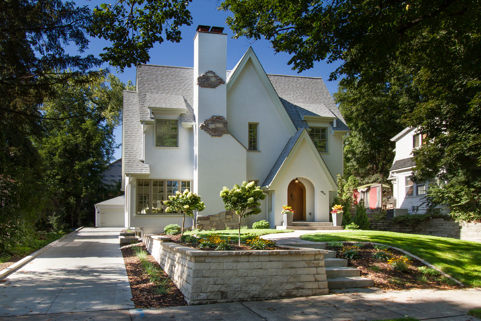 Cette image montre une façade de maison blanche traditionnelle en stuc de taille moyenne et à un étage.