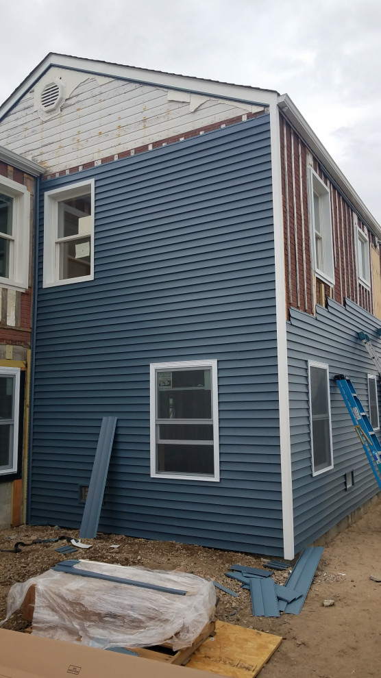 Mittelgroßes, Zweistöckiges Maritimes Einfamilienhaus mit Vinylfassade, blauer Fassadenfarbe, Walmdach und Schindeldach in New York
