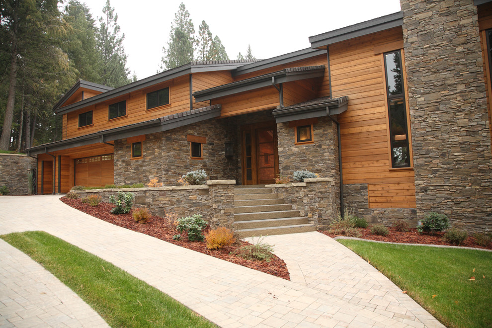 Exemple d'une très grande façade de maison marron craftsman en bois à un étage avec un toit à croupette.