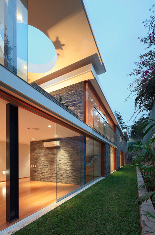 Large minimalist white split-level glass exterior home photo in Other