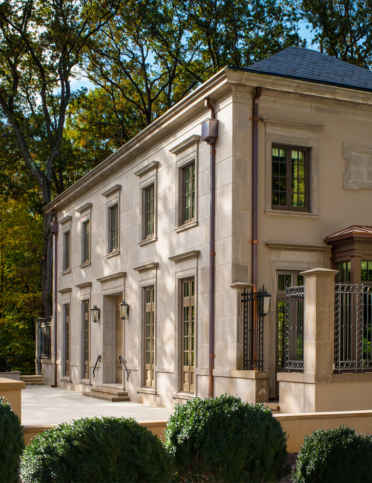 Imagen de fachada de casa beige clásica grande de dos plantas con revestimiento de piedra, tejado a cuatro aguas y tejado de teja de barro