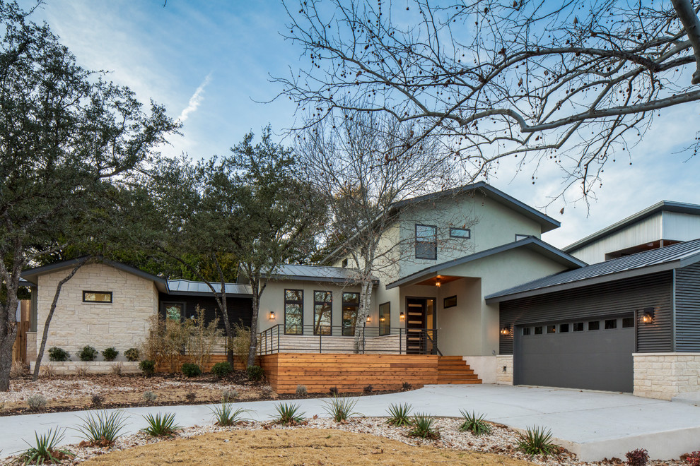 Réalisation d'une grande façade de maison verte design à un étage avec un revêtement mixte, un toit à deux pans et un toit en métal.