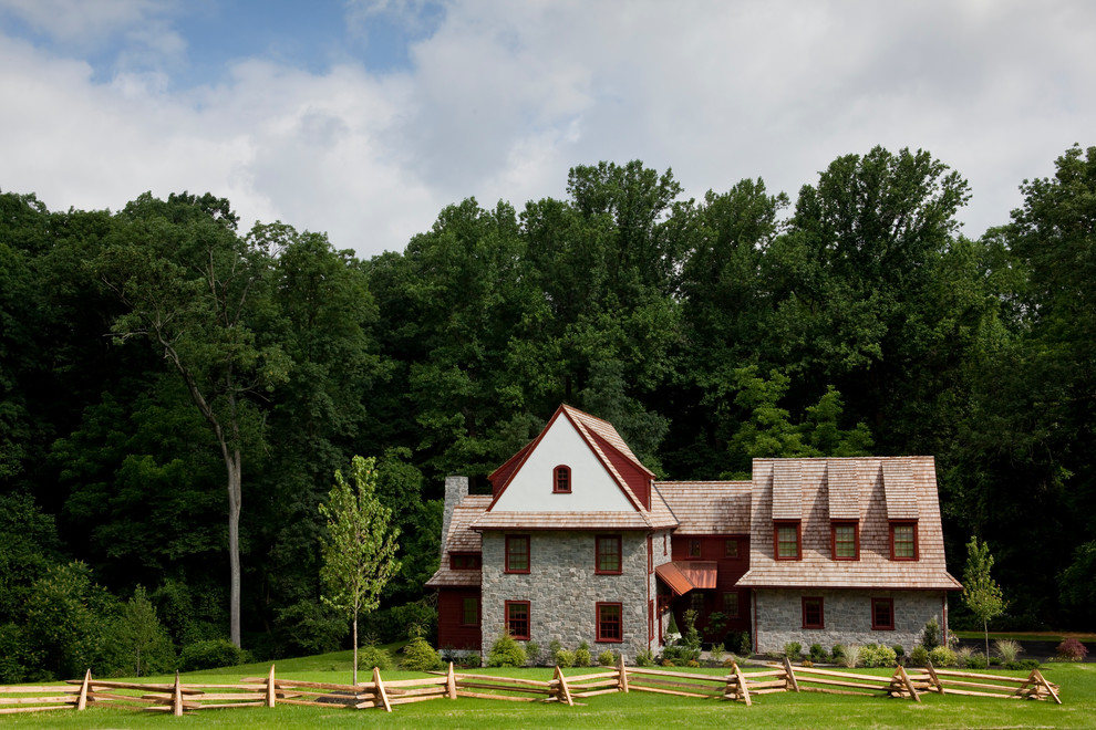Immagine della facciata di una casa grande rossa country a tre piani con rivestimenti misti