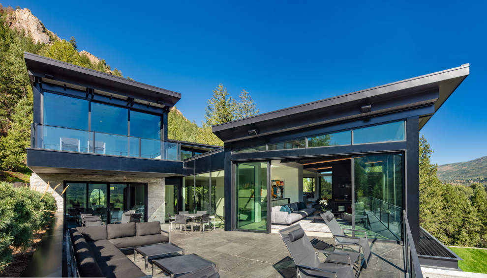 Exemple d'une grande façade de maison multicolore tendance en verre à deux étages et plus avec un toit en appentis et un toit végétal.