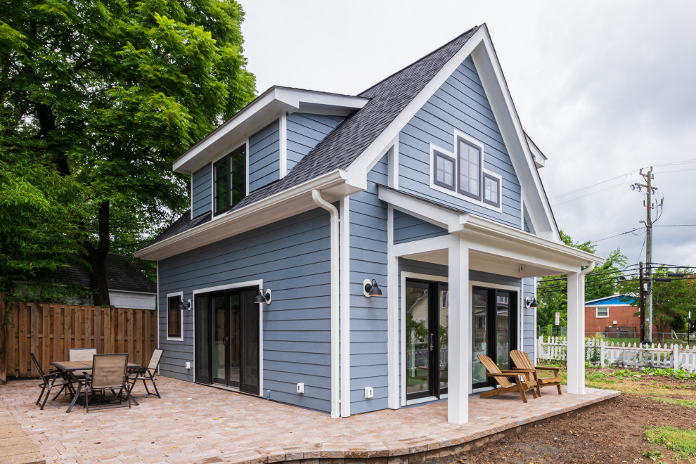 Cette image montre une petite façade de Tiny House bleue en bois à un étage avec un toit à deux pans.