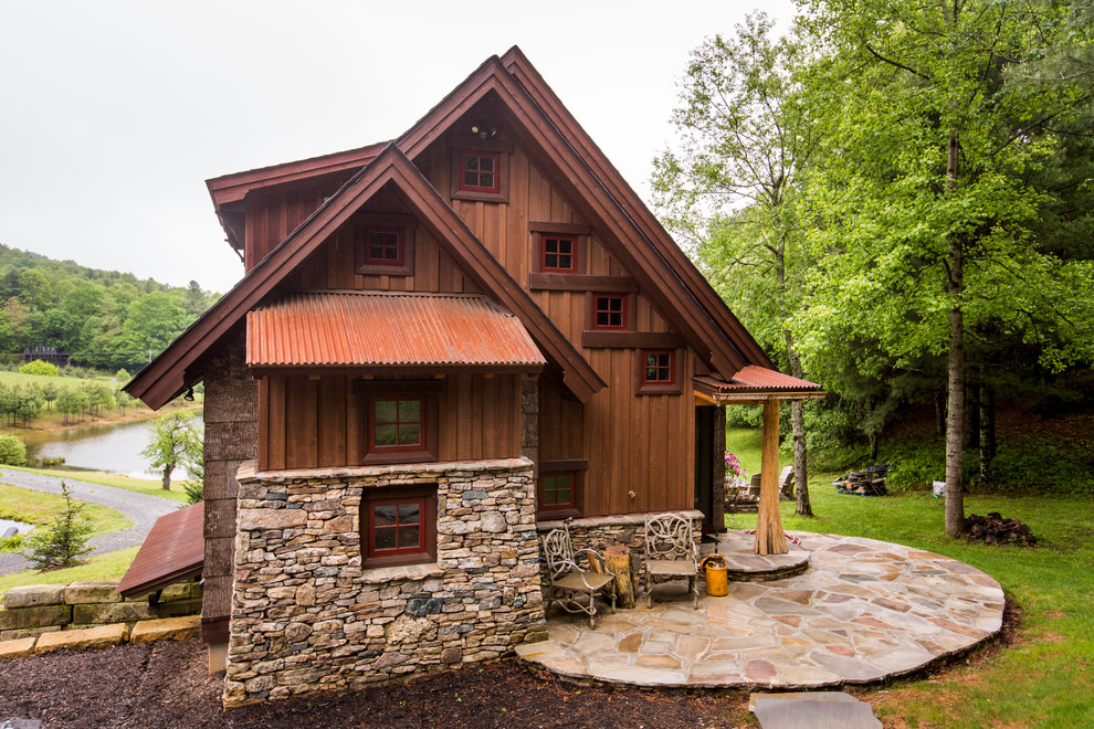 Inspiration for a rustic house exterior in Charlotte with wood cladding and a pitched roof.