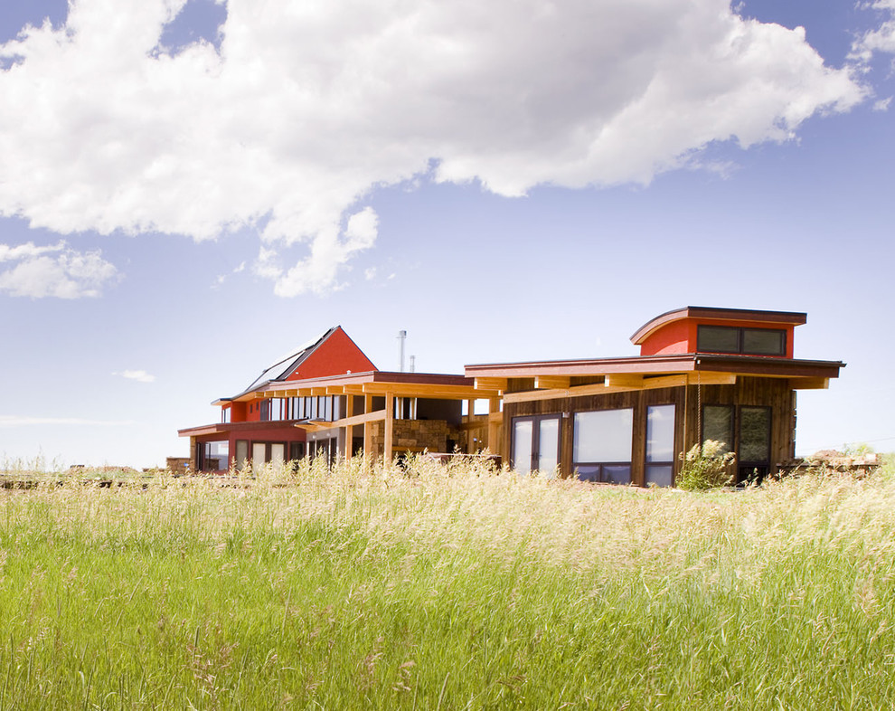 Идея дизайна: красный частный загородный дом среднего размера в современном стиле с комбинированной облицовкой и металлической крышей