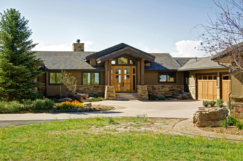 Стильный дизайн: большой, одноэтажный, коричневый дом в стиле рустика с облицовкой из цементной штукатурки и двускатной крышей - последний тренд