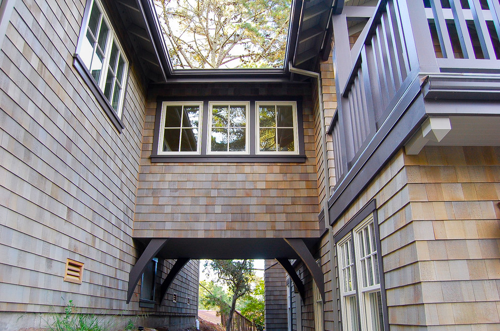Foto della facciata di una casa grande beige american style a tre piani con rivestimento in legno e tetto a capanna