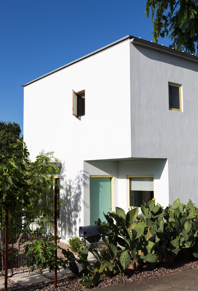 Modelo de fachada de casa blanca bohemia pequeña de dos plantas con revestimiento de estuco, tejado plano y tejado de metal