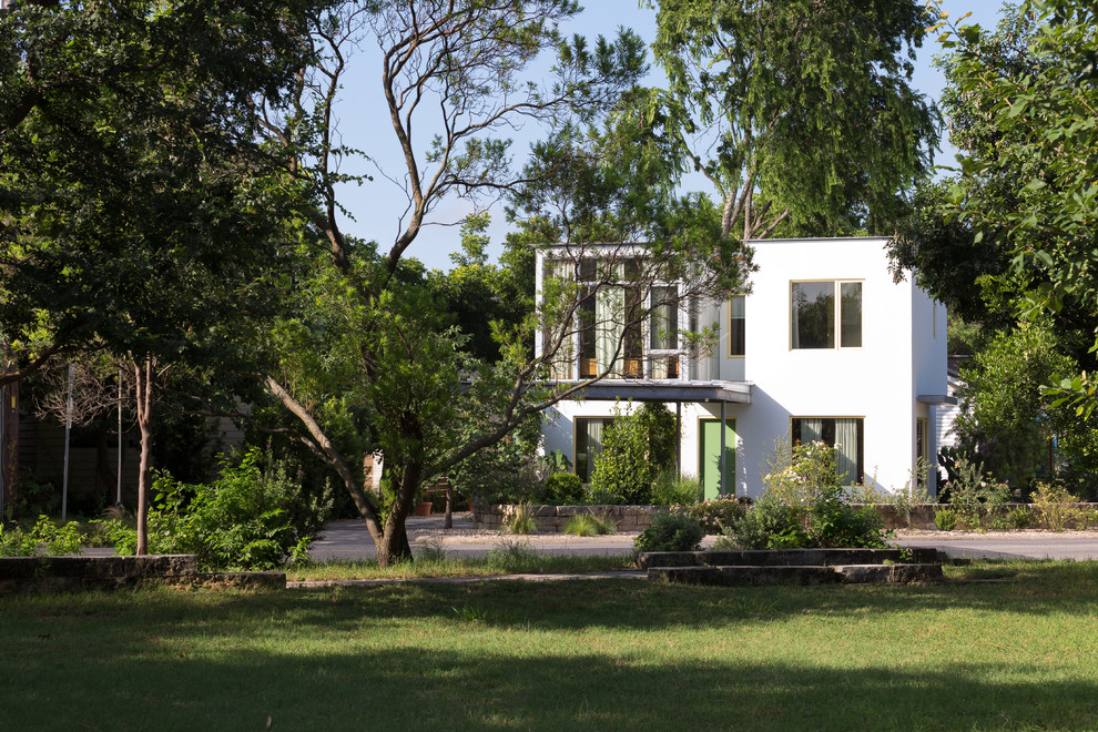 Modelo de fachada de casa blanca ecléctica pequeña de dos plantas con revestimiento de estuco, tejado plano y tejado de metal
