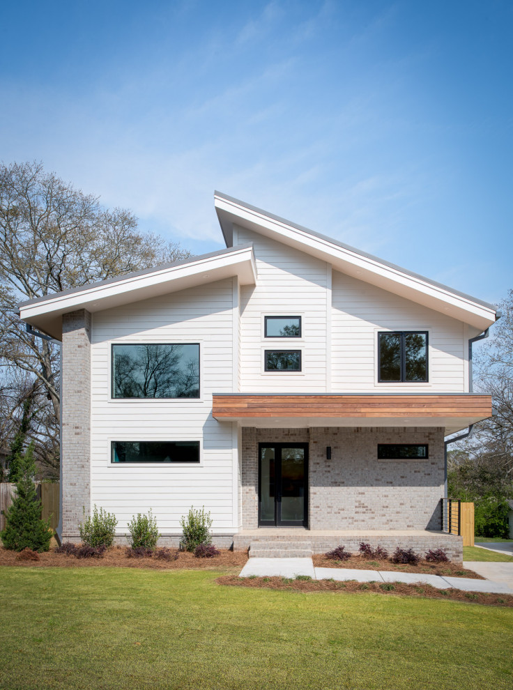 Foto de fachada de casa moderna de tamaño medio de dos plantas con tejado de un solo tendido y tejado de metal