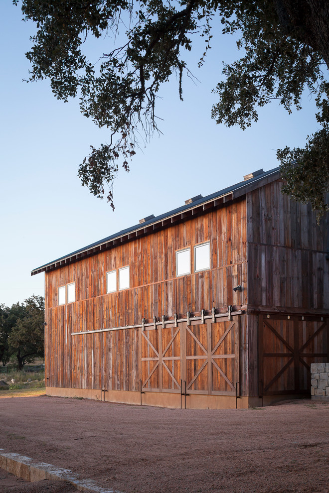 Design ideas for a rustic house exterior in Austin with wood cladding.