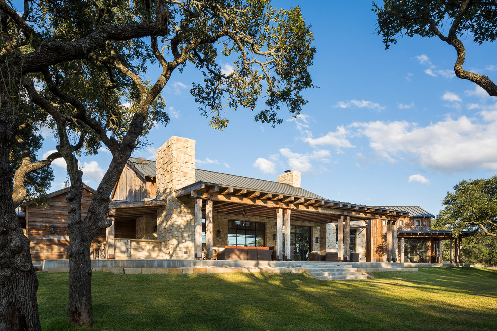 Inspiration for a rustic house exterior in Austin with mixed cladding.