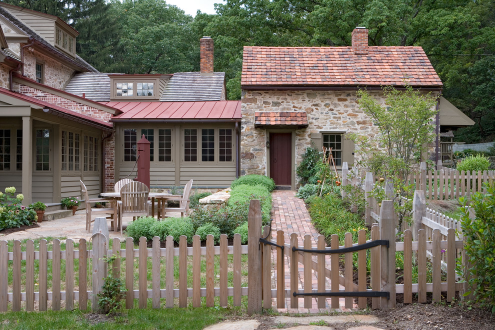 Modelo de fachada beige de estilo de casa de campo de dos plantas con revestimiento de piedra