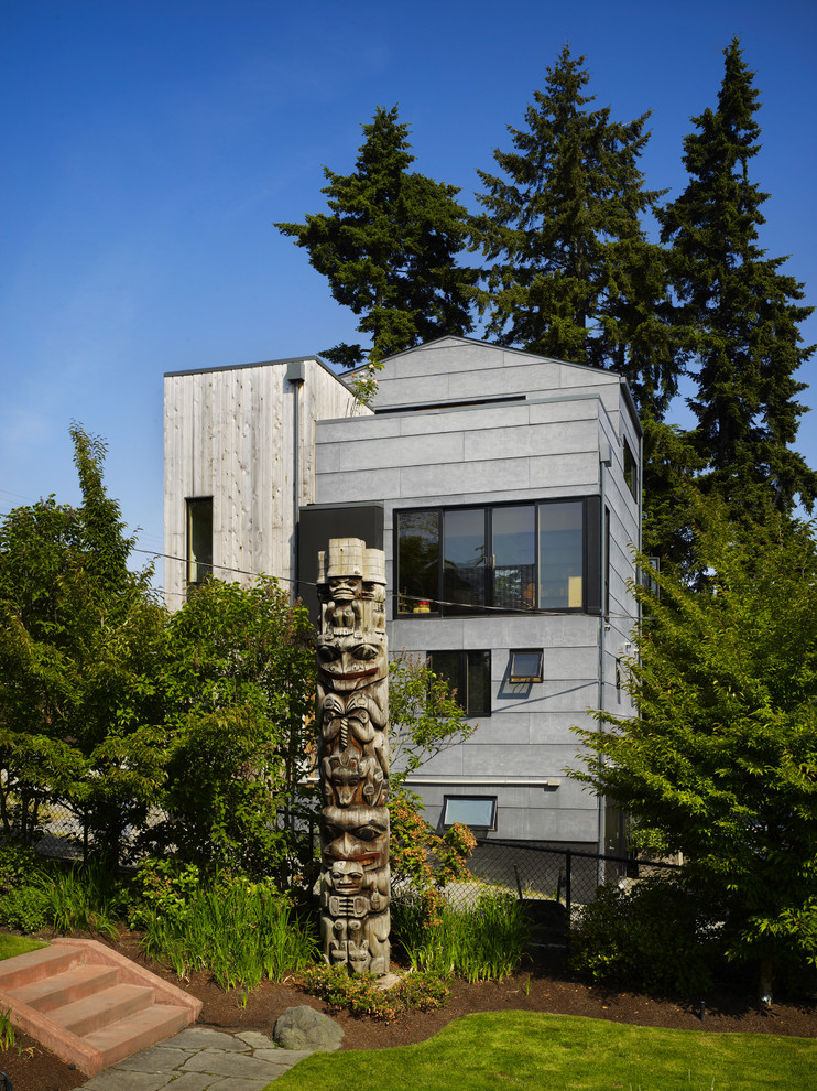Пример оригинального дизайна: трехэтажный, серый дом среднего размера в стиле модернизм с комбинированной облицовкой и двускатной крышей