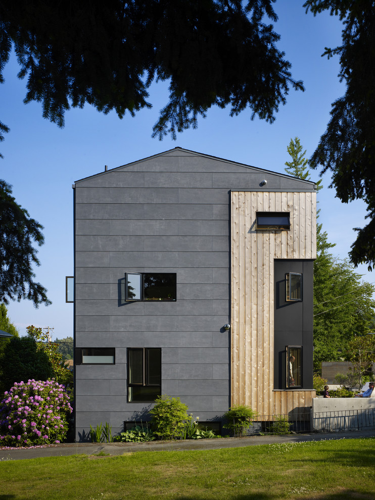 Стильный дизайн: трехэтажный, серый дом среднего размера в современном стиле с комбинированной облицовкой и двускатной крышей - последний тренд