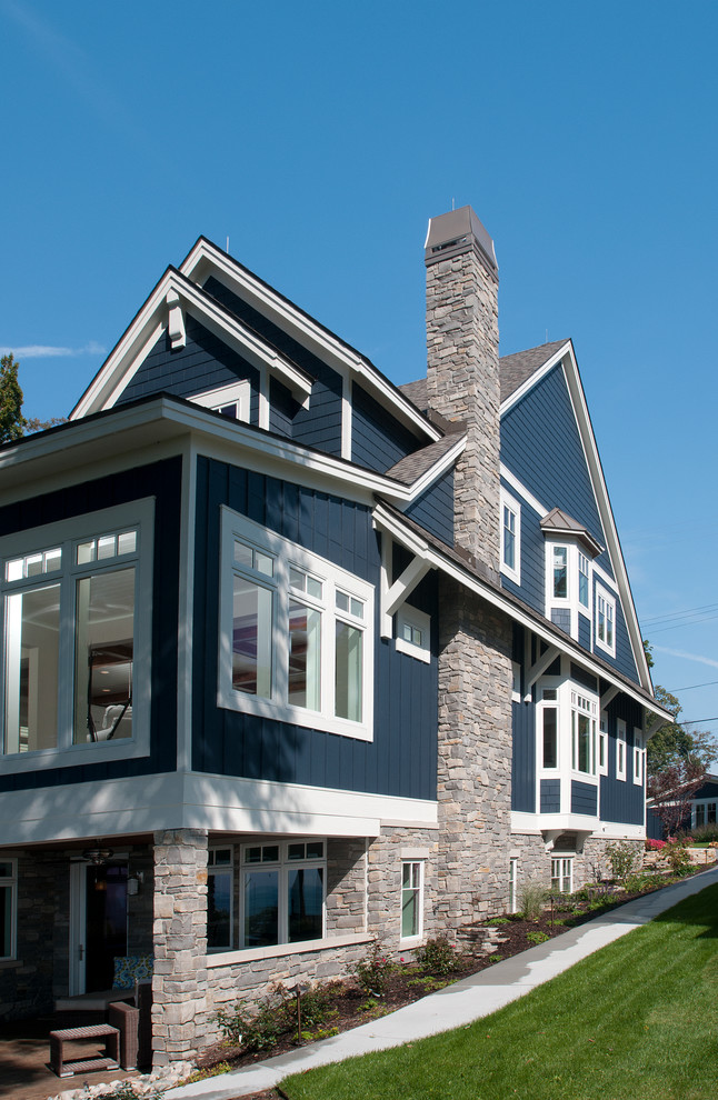 Aménagement d'une façade de maison bleue bord de mer en panneau de béton fibré de taille moyenne et à deux étages et plus avec un toit à deux pans.