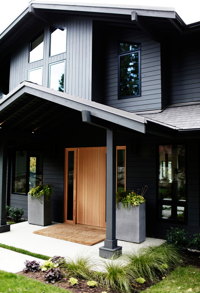 Cette photo montre une grande façade de maison grise tendance en bois à un étage avec un toit de Gambrel.