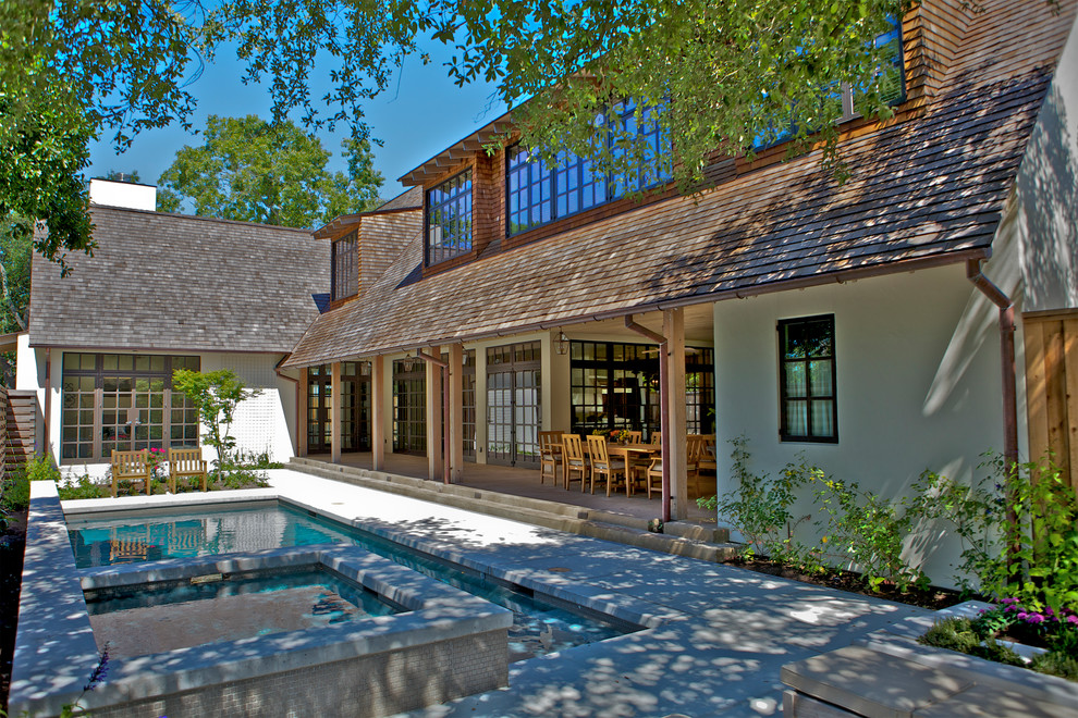 Diseño de fachada de casa beige clásica grande de dos plantas con revestimiento de estuco, tejado a dos aguas y tejado de teja de madera