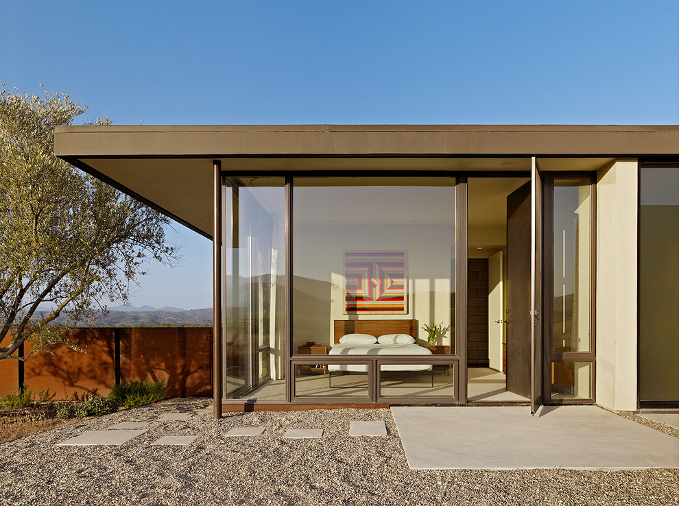 Cette image montre une façade de maison minimaliste de plain-pied avec un toit plat.