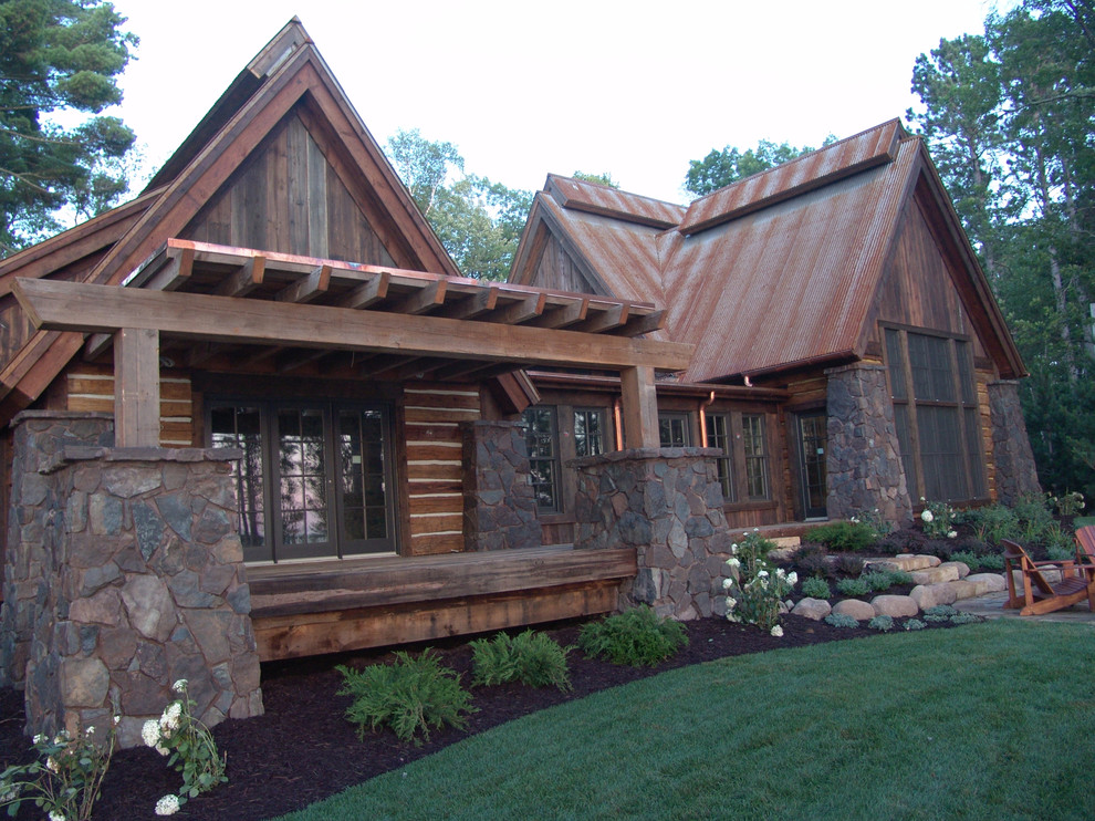 Inspiration pour une grande façade de maison chalet avec un revêtement mixte et un toit en métal.