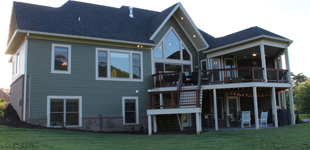 Cette image montre une grande façade de maison verte craftsman de plain-pied avec un revêtement mixte et un toit à quatre pans.
