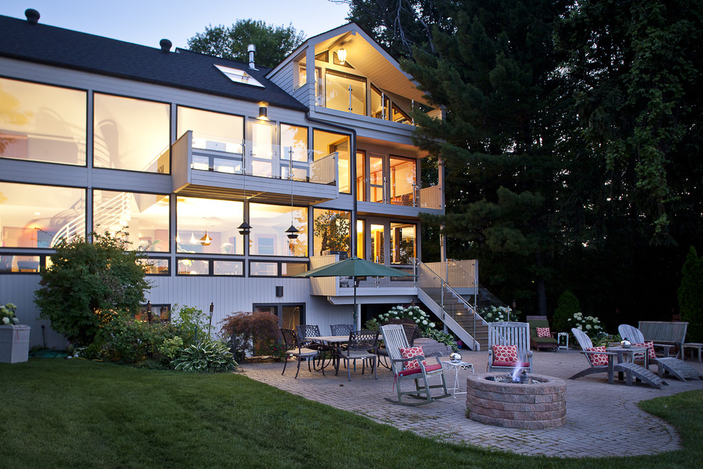 Design ideas for a classic glass house exterior in Detroit with three floors.