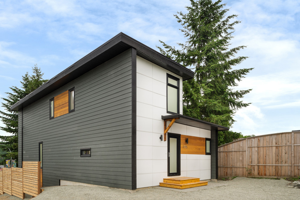 Imagen de fachada gris moderna de tamaño medio de tres plantas con revestimiento de aglomerado de cemento