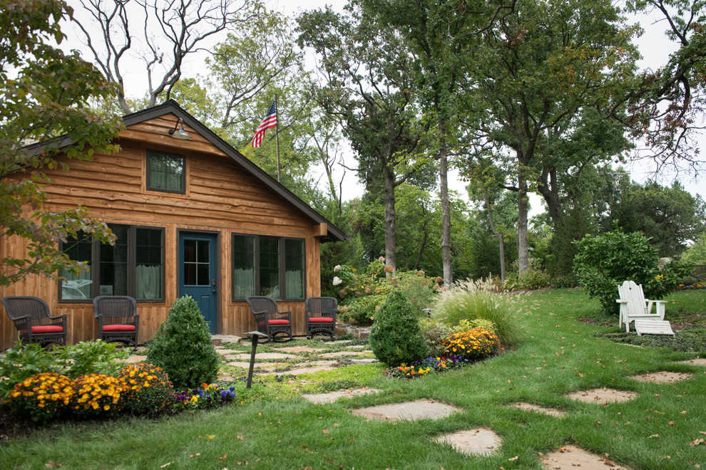 Пример оригинального дизайна: деревянный, коричневый частный загородный дом в стиле рустика с двускатной крышей