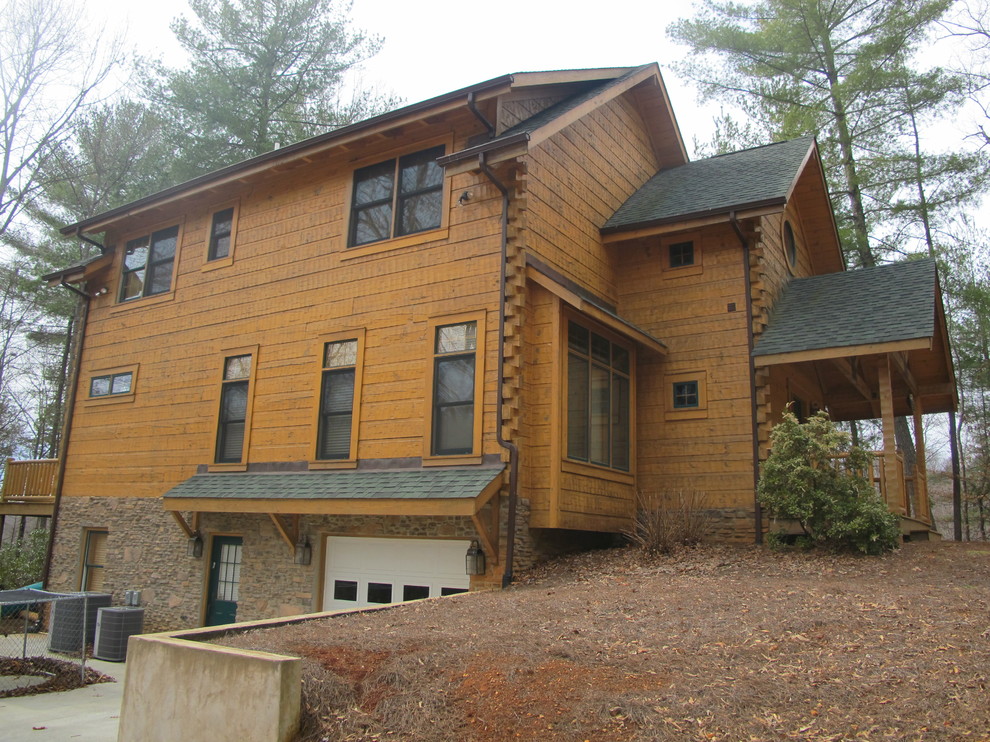 Inspiration pour une grande façade de maison marron chalet en bois à un étage avec un toit à deux pans.