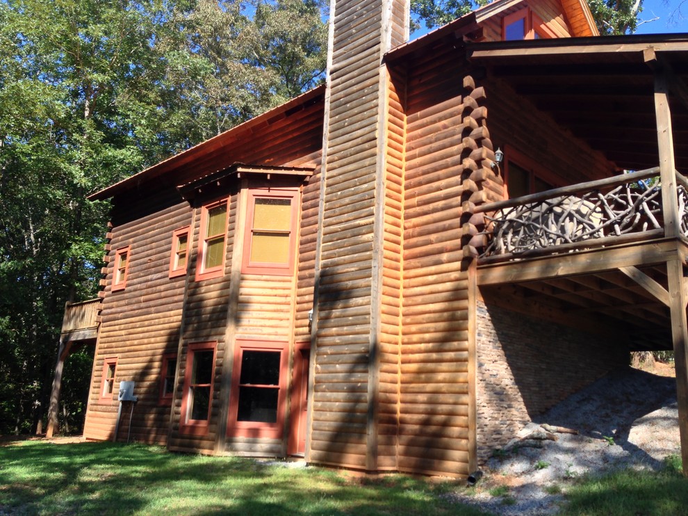 Immagine della facciata di una casa rustica a due piani di medie dimensioni con rivestimento in legno