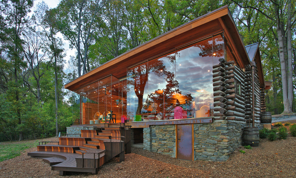 Aménagement d'une grande façade de maison marron montagne en verre à un étage avec un toit en appentis et un toit en métal.