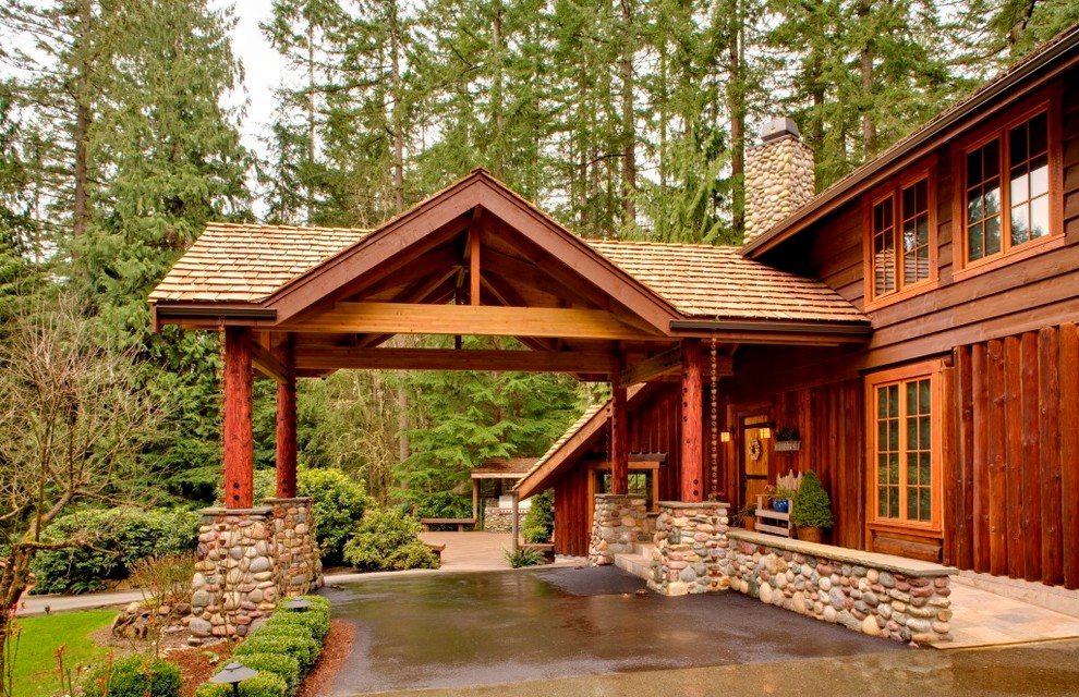 Пример оригинального дизайна: большой, одноэтажный, деревянный, коричневый частный загородный дом в стиле рустика с двускатной крышей и крышей из гибкой черепицы