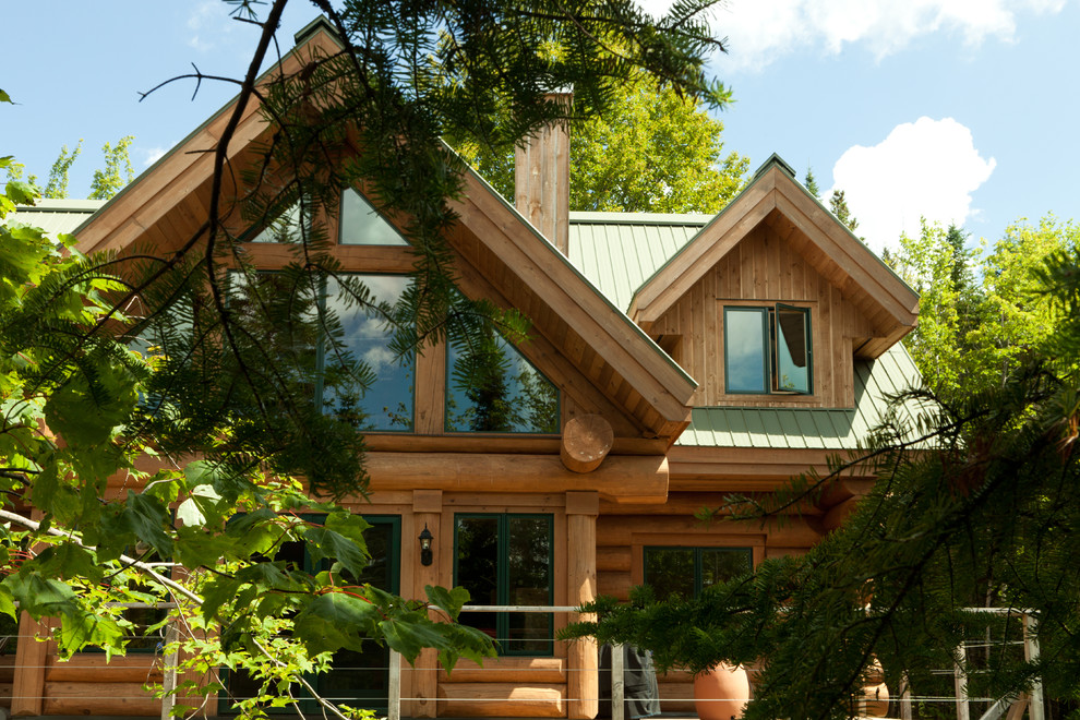 Imagen de fachada de casa marrón rústica de tamaño medio de dos plantas con revestimiento de madera, tejado a dos aguas y tejado de metal