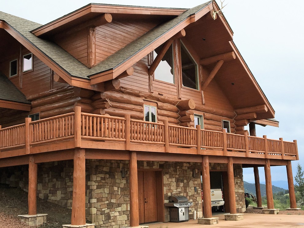 Idées déco pour une grande façade de maison marron montagne en bois à niveaux décalés avec un toit à croupette.