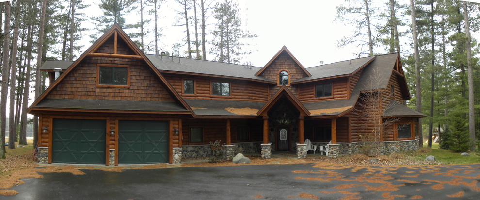 Cette image montre une façade de maison marron chalet en bois de taille moyenne et à un étage avec un toit à deux pans et un toit en shingle.