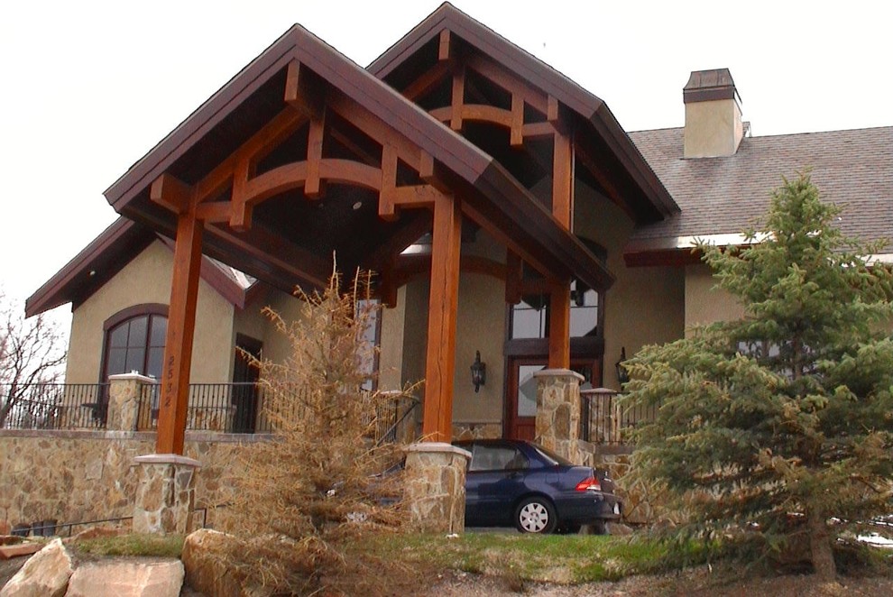 Foto della facciata di una casa grande beige american style a due piani con rivestimento in stucco e tetto a capanna
