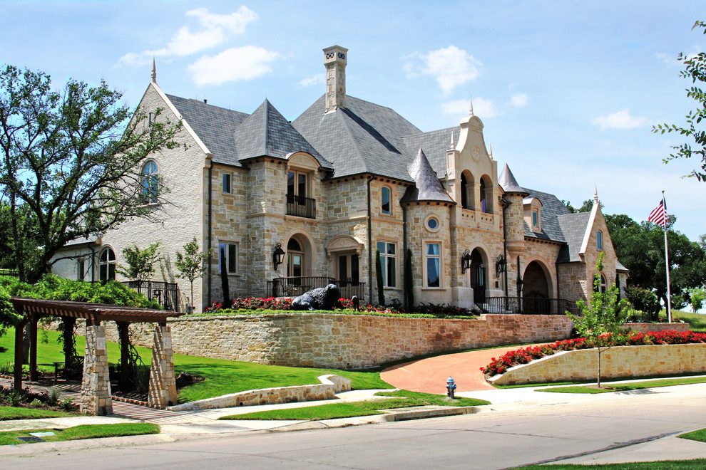 Cette photo montre une grande façade de maison beige chic en pierre à un étage.